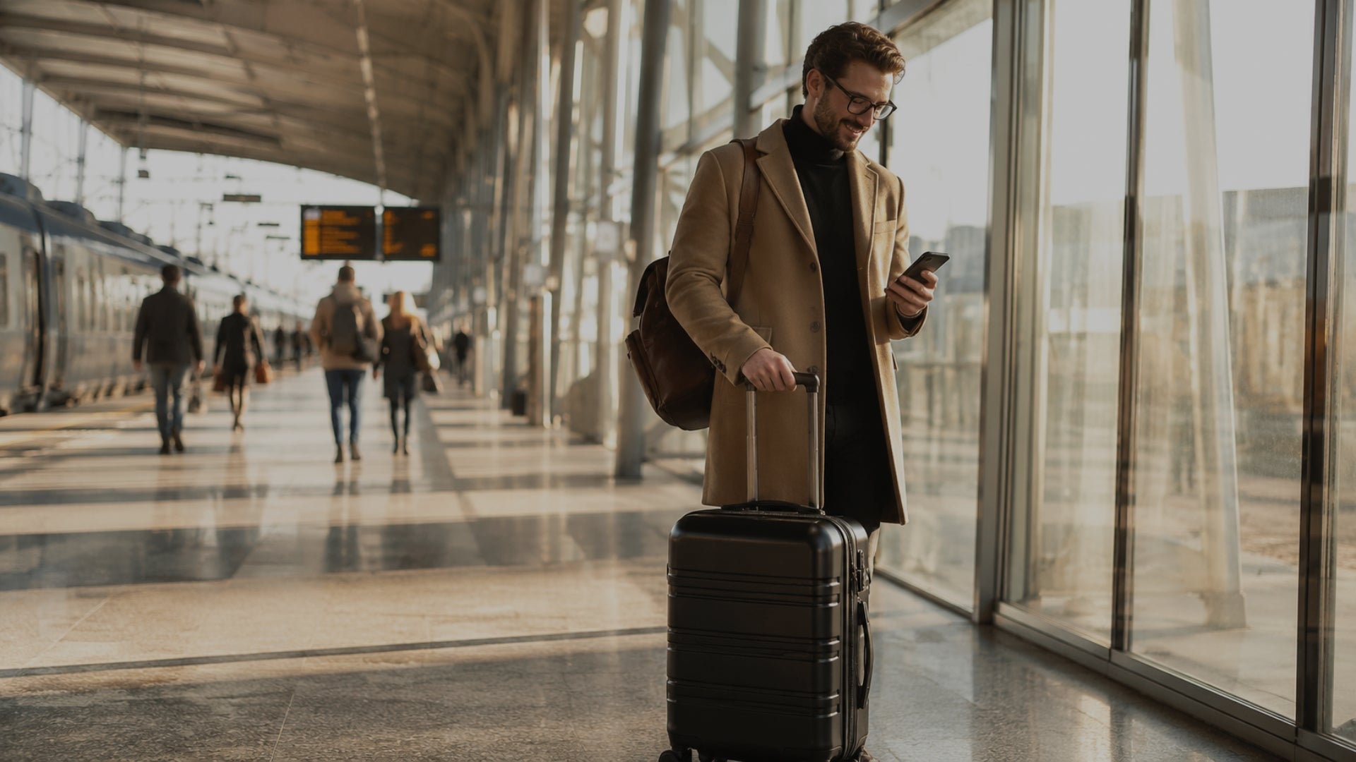 Man with suitcase and phone at an airport terminal